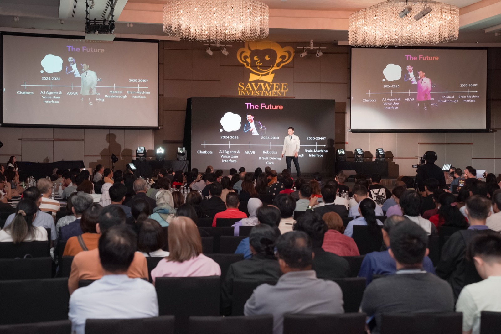 Meng Teck on stage at a Savwee Investment live event with hundreds of Malaysian investors